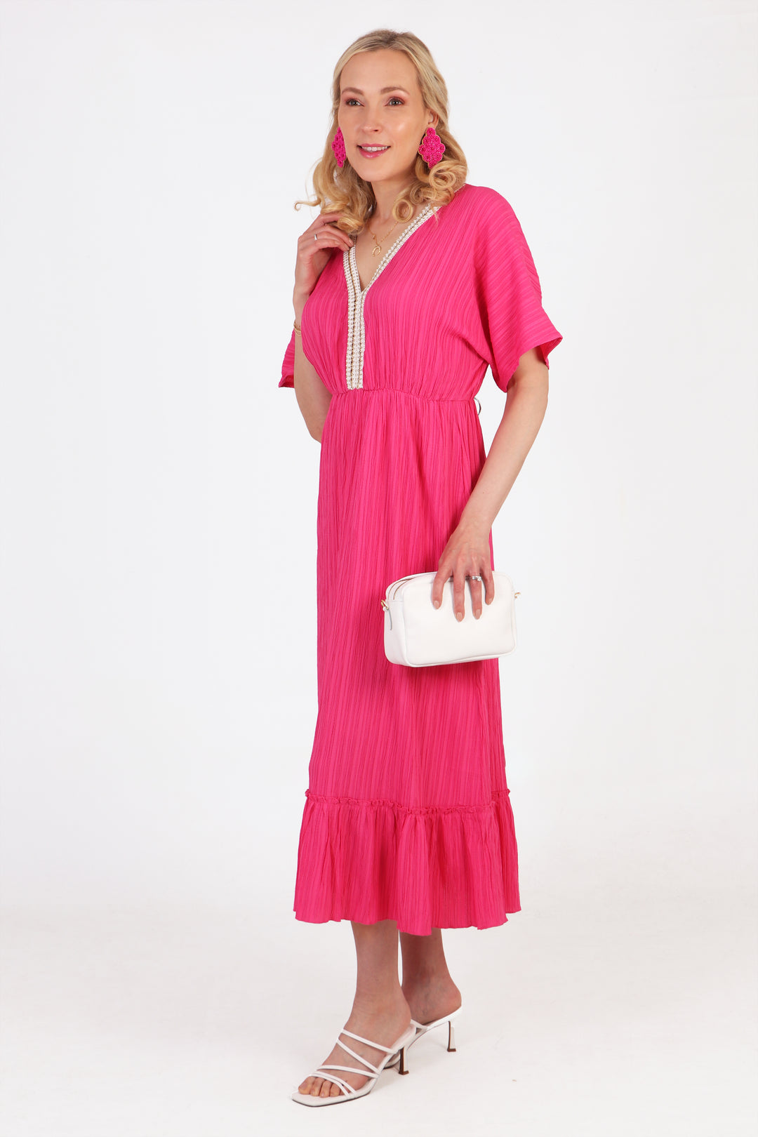 pink midi kaftan dress accessorised with white sandals, white clutch bag and pink earrings