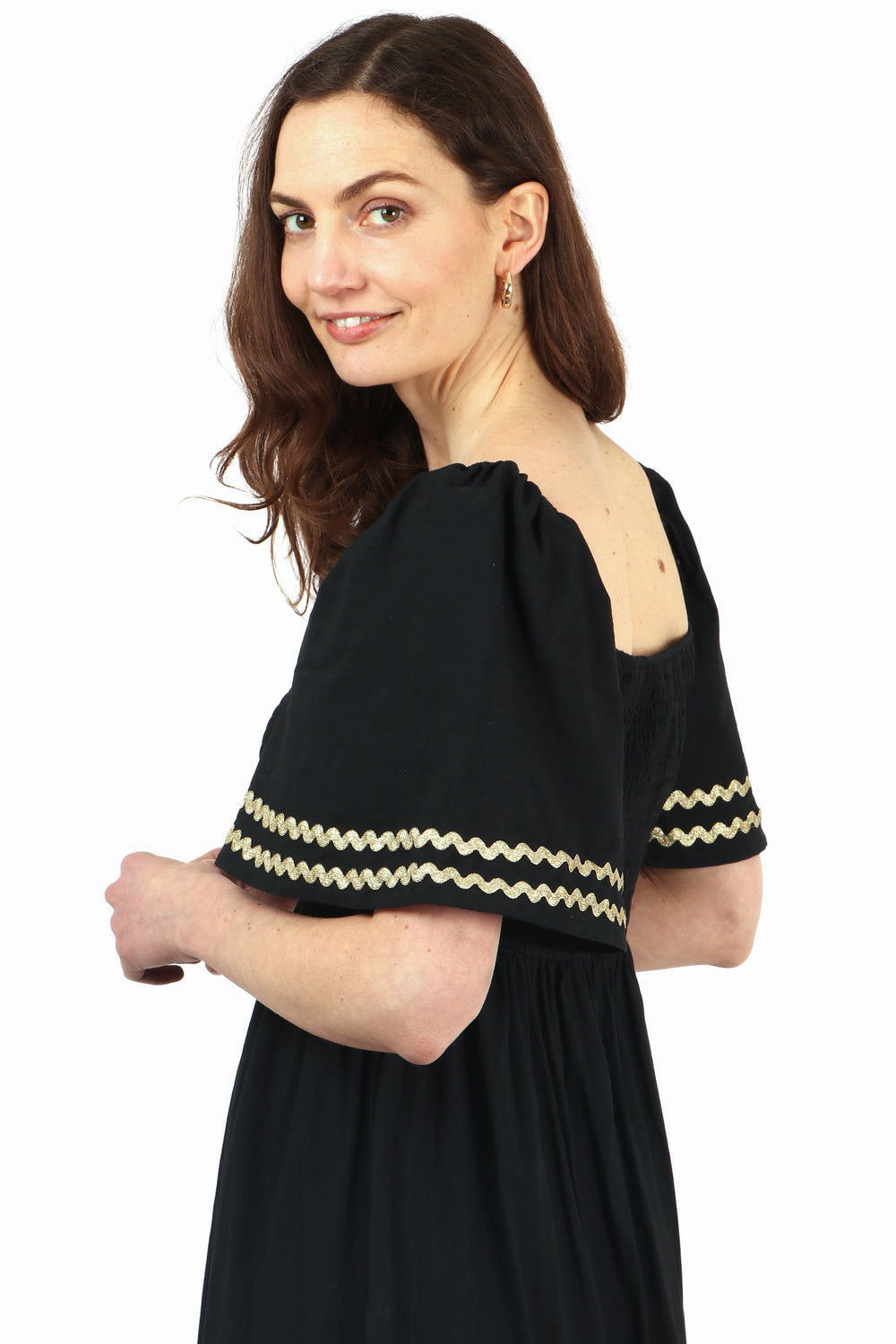 close up of the gold trim on the bell sleeves, showing also the square neck line