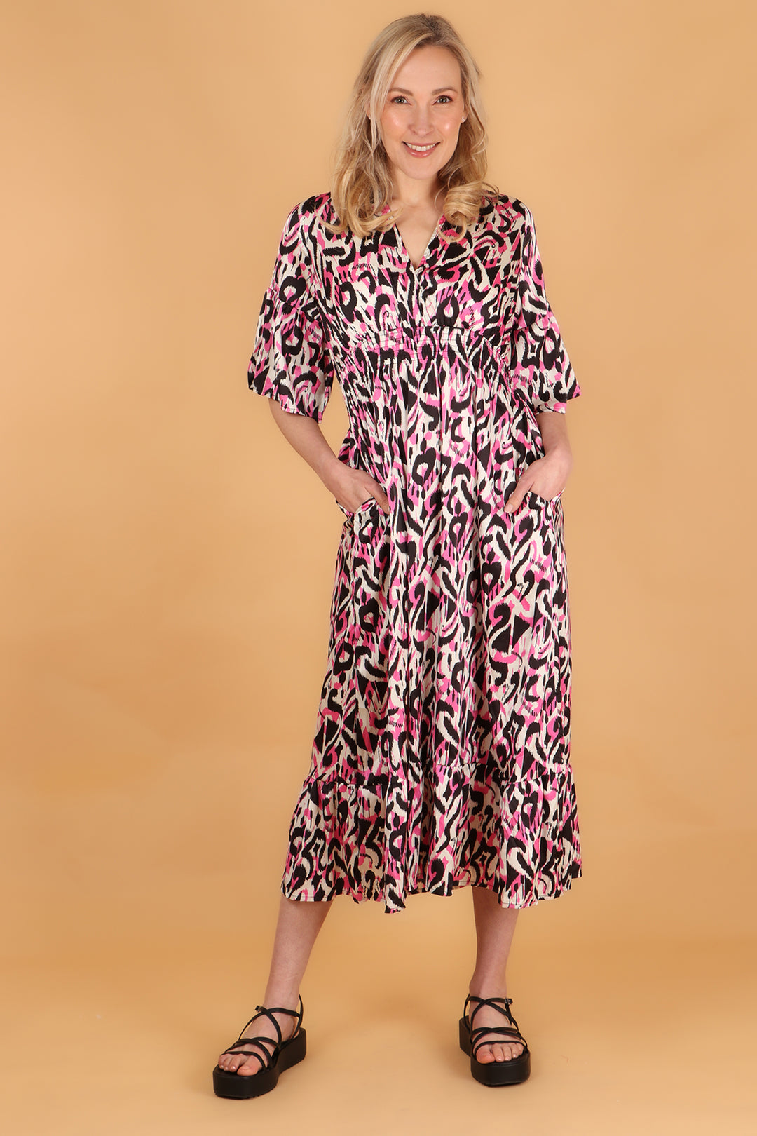 model wearing a maxi length pink ikat print dress with 3/4 fluted sleeves
