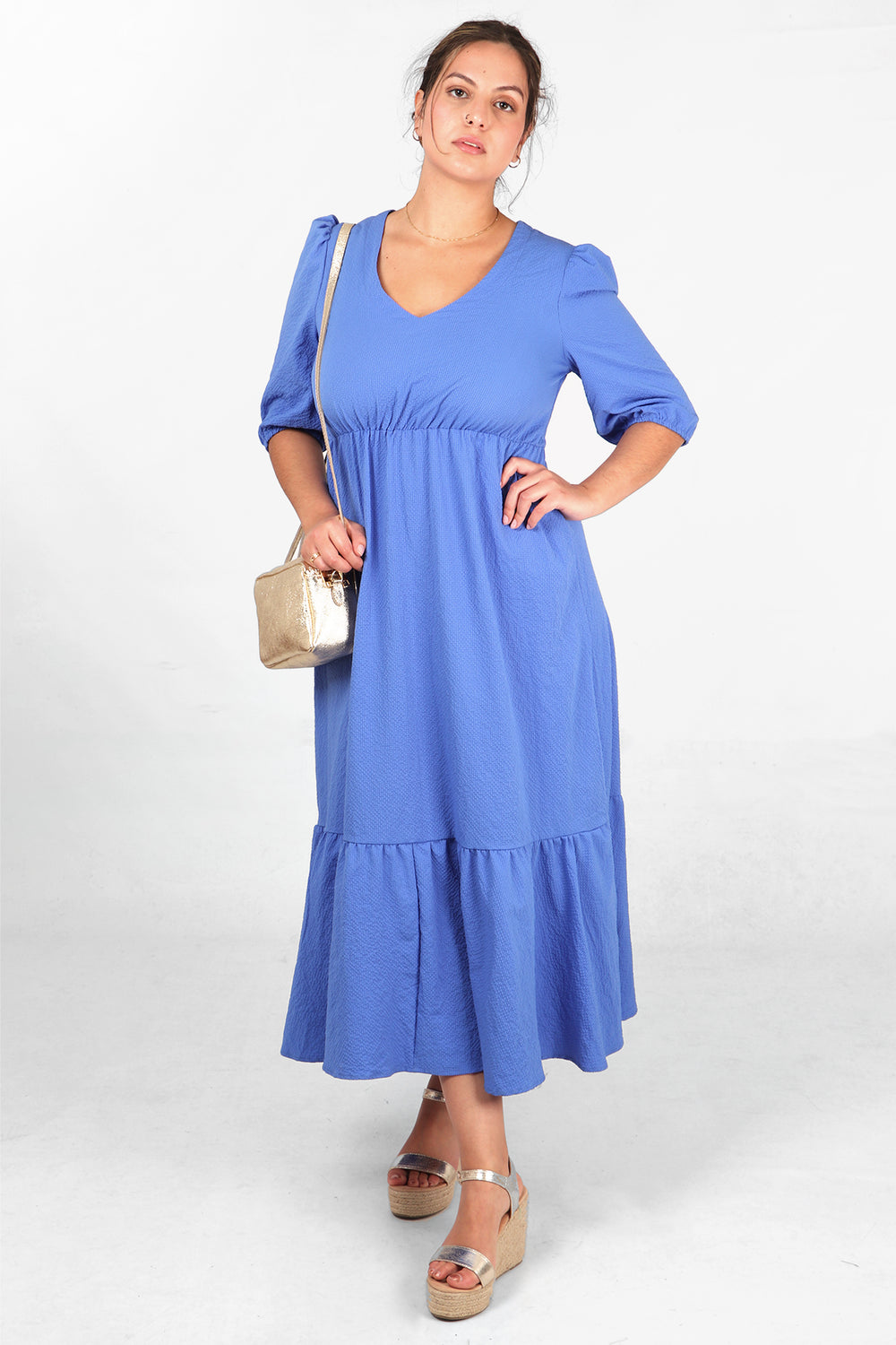 model wearing a plain blue tiered midaxi length dress with elasticated waist