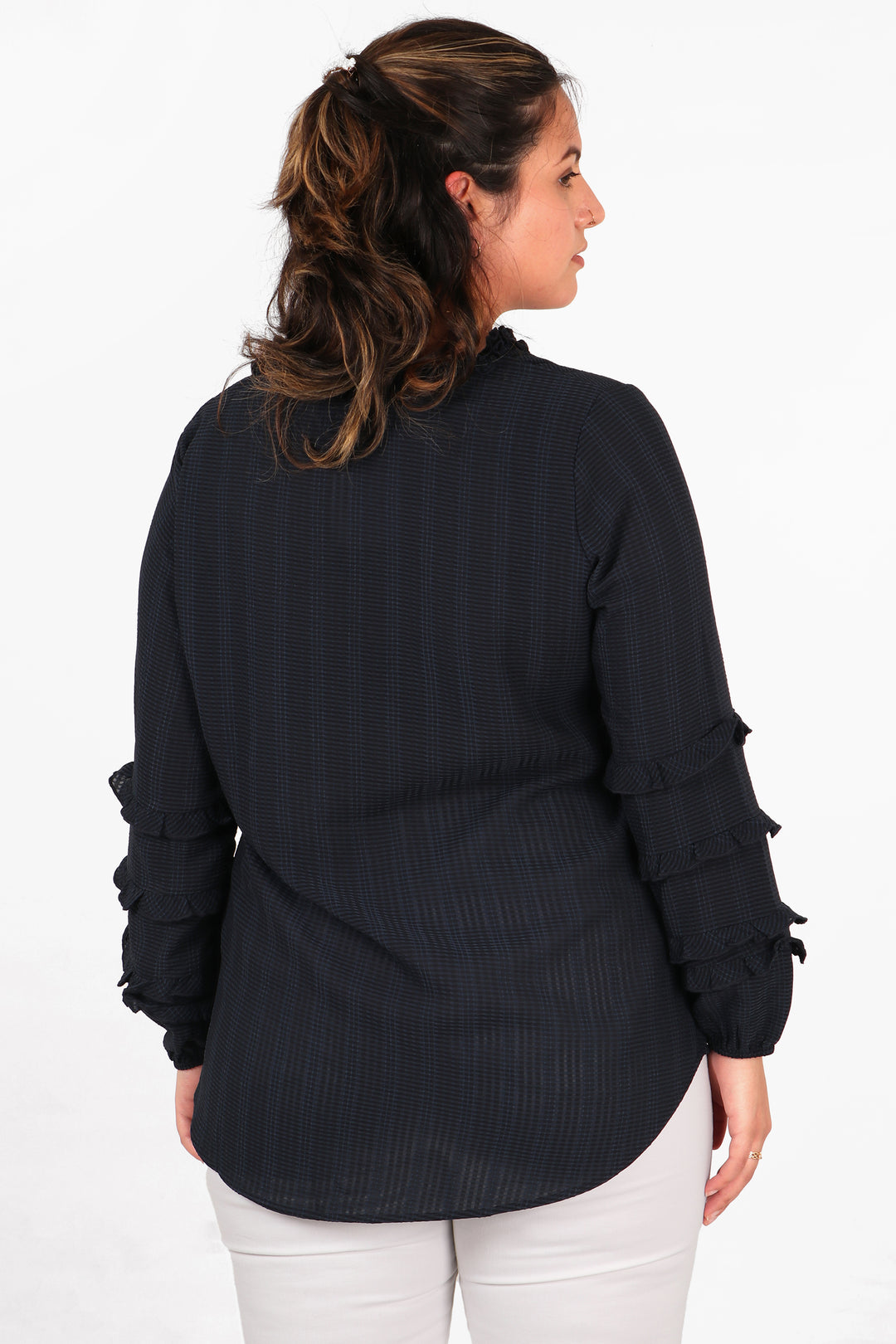 model showing the back of the navy blue shirt, showing the frill details on the sleeves