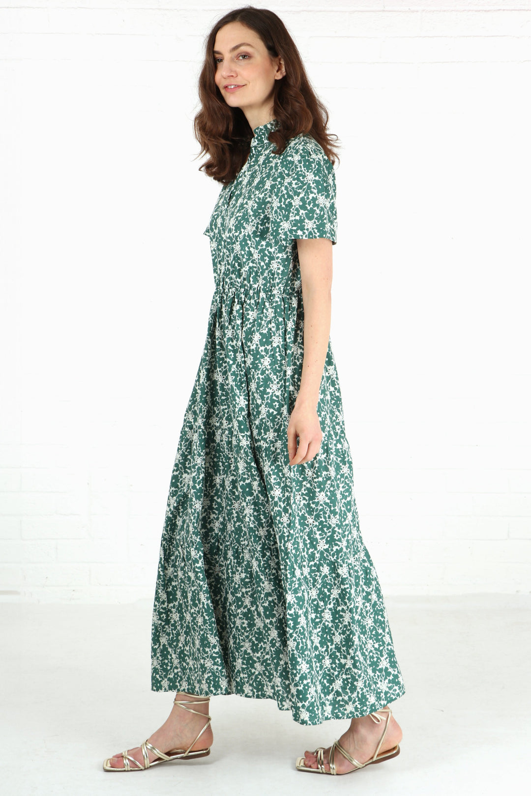 model wearing a maxi length green and white tiered dress with short shirt sleeves