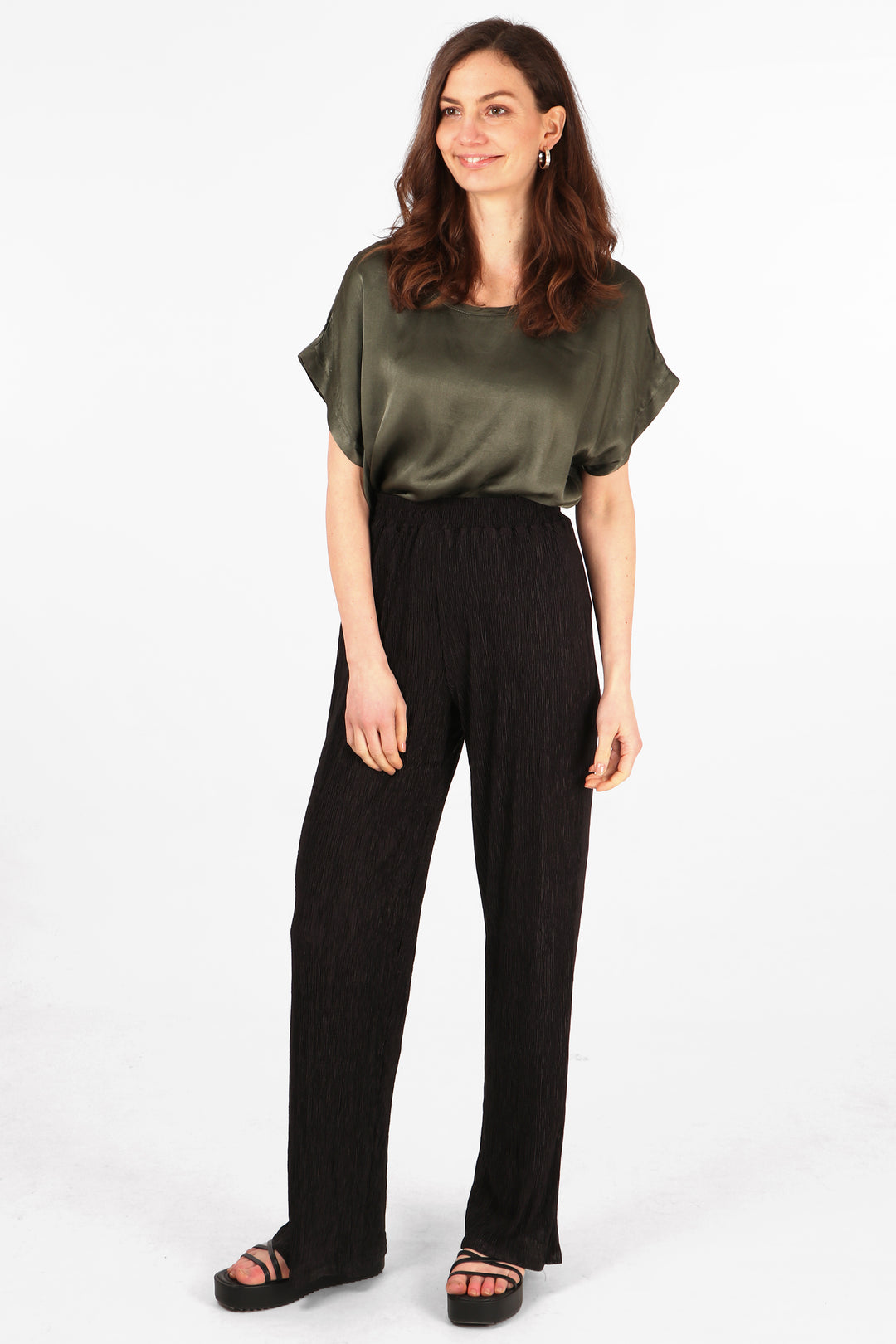 model wearing black plisse trousers with an elasticated waist