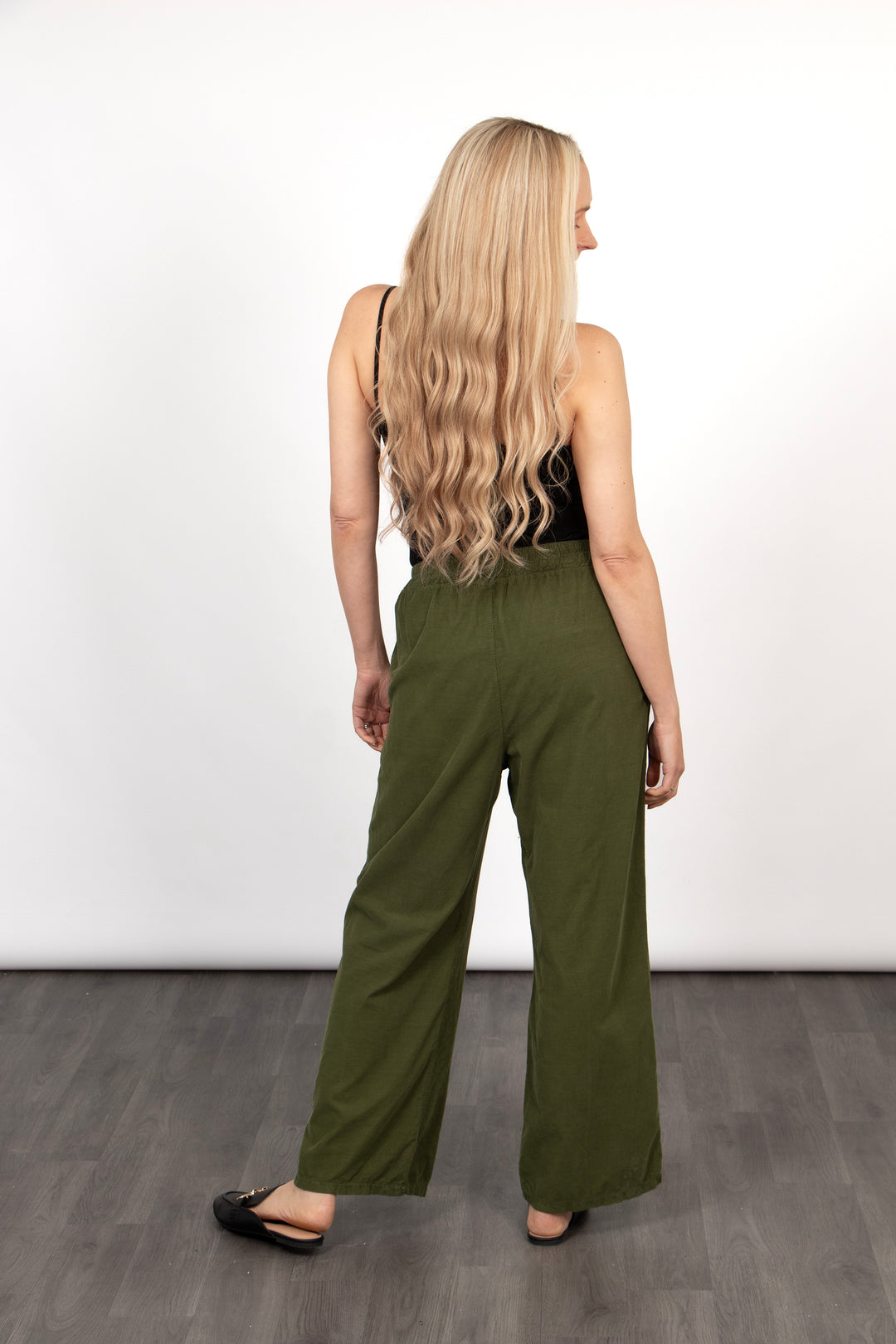 model showing the back of the green khaki cord trousers, showing the wide leg design