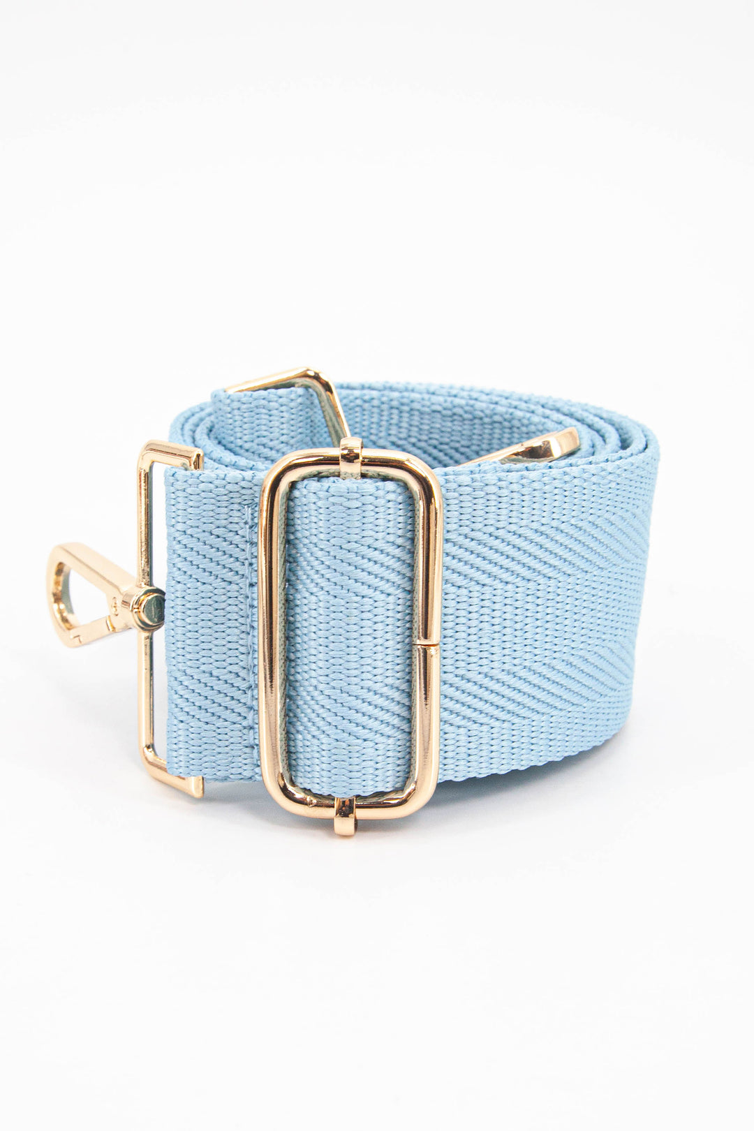 close up of the adjustable bag strap, showing the gold buckle and clip on attachments
