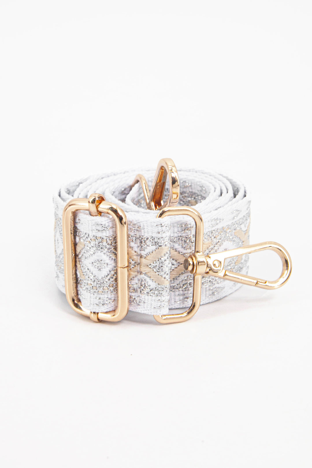 showing the bag strap coiled around itself, the silver and gold metallic woven design is prominent , the gold hardware is shown in close up