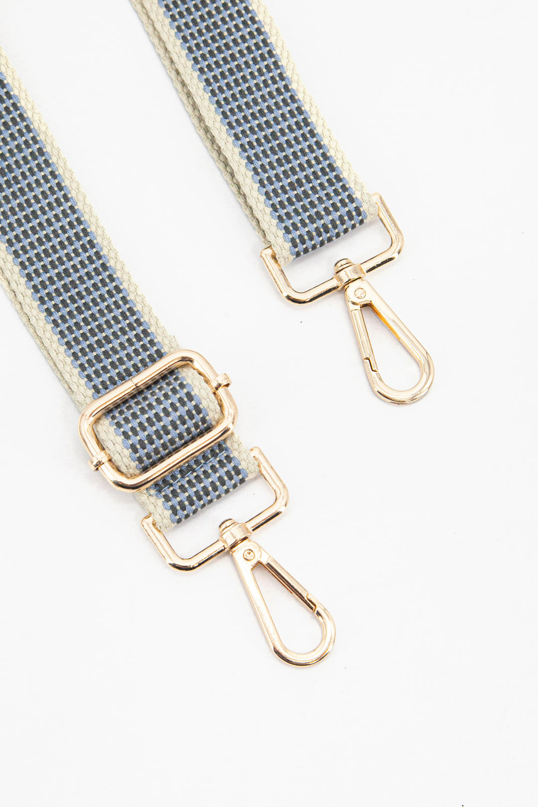 close up of the gold clip on snap hook and adjustable buckle on the bag strap