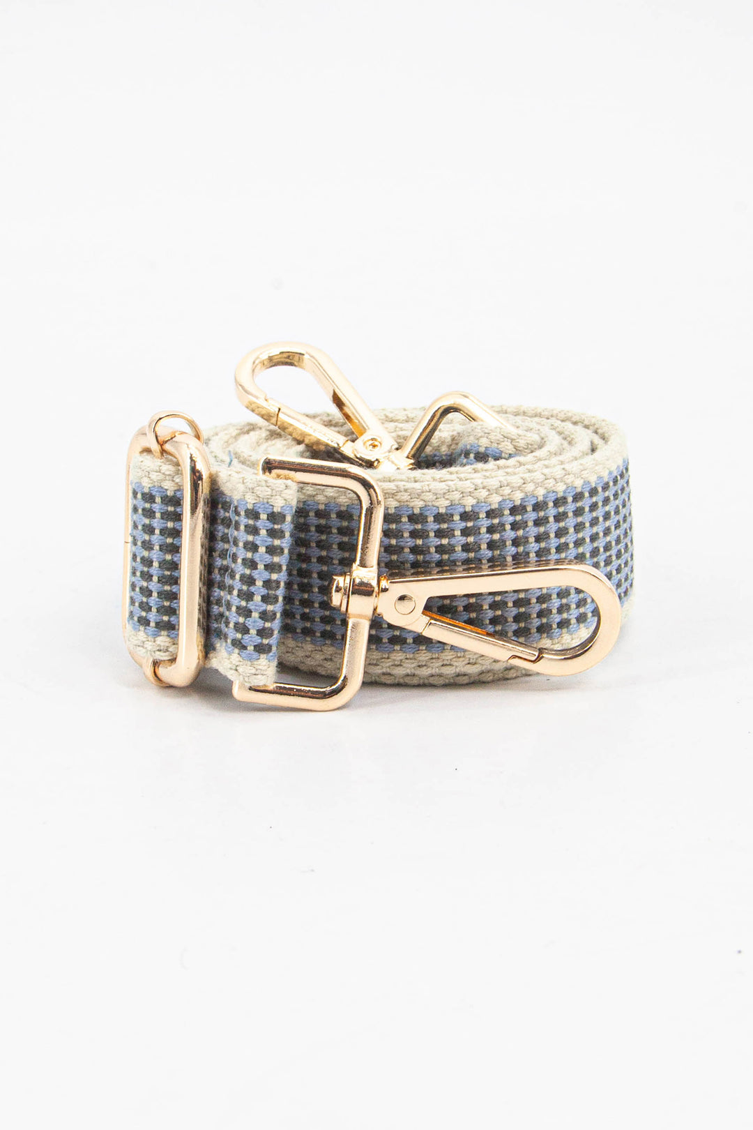 showing the bag strap coiled around itself, the blue rattan woven design is prominent , the gold hardware is shown in close up