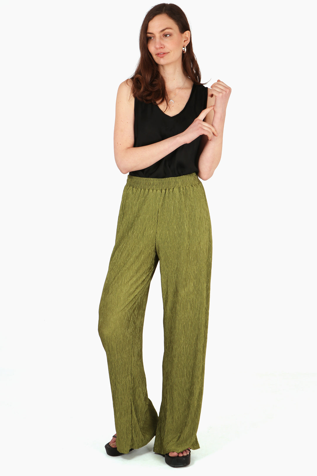 model wearing a pair of plisse material long trousers in an olive green colour