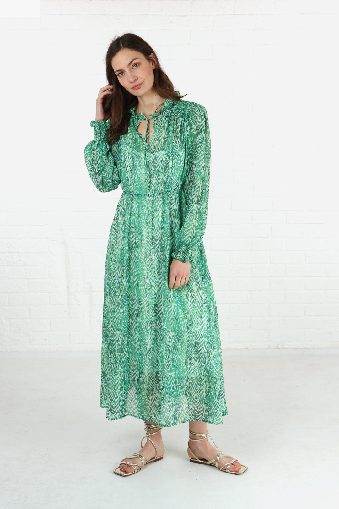 model wearing a green chevron print shirred shoulder midi dress