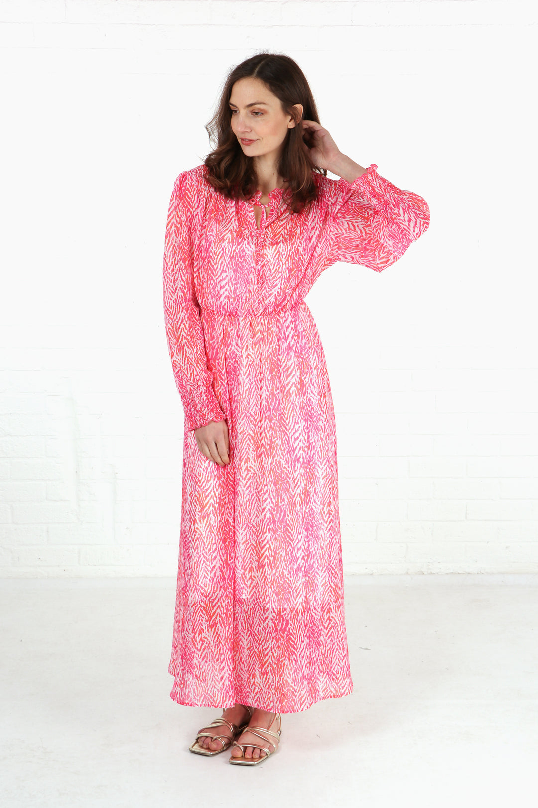 model wearing a pink chevron print shirred shoulder midi dress