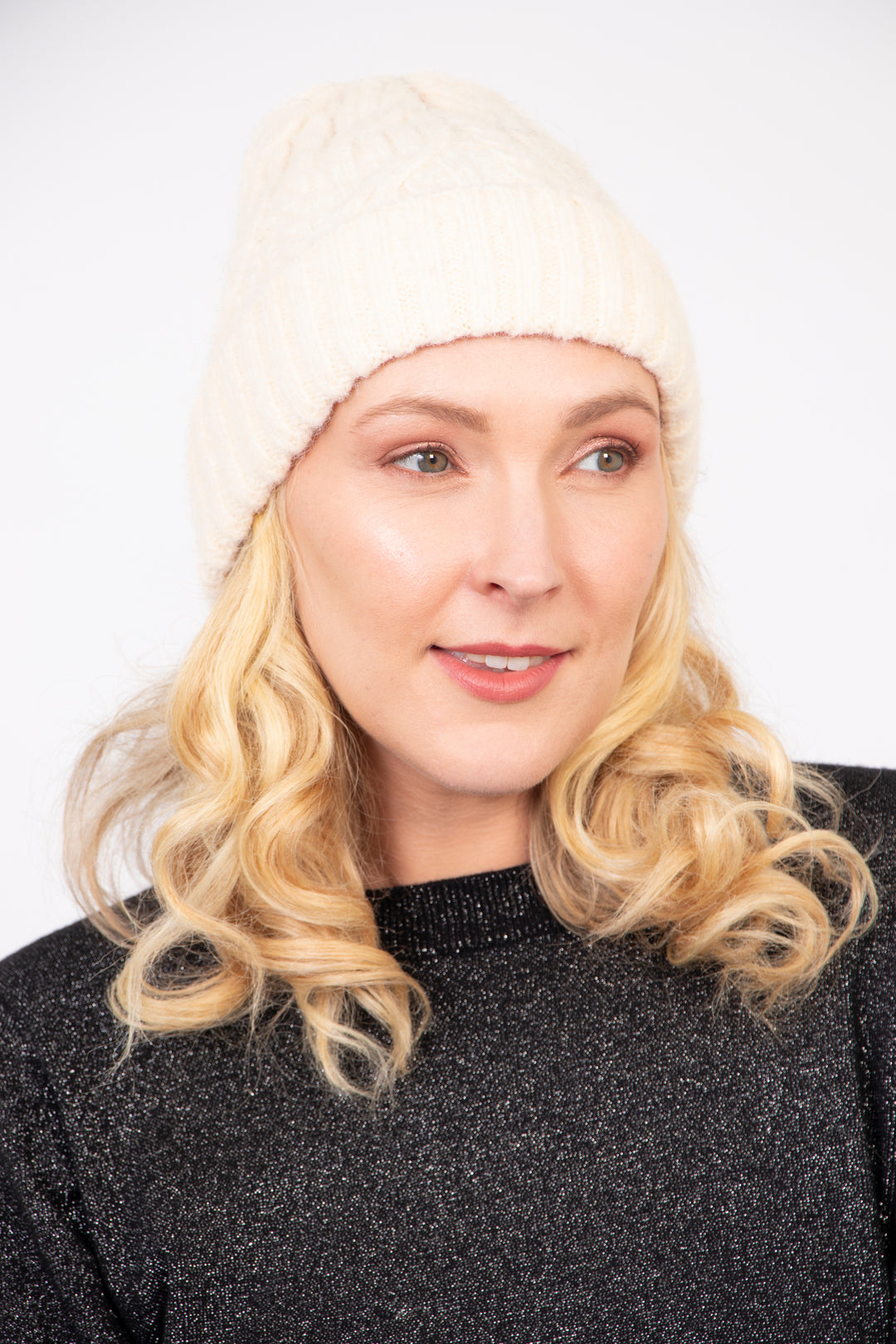 model wearing a cream cable knit winter beanie hat