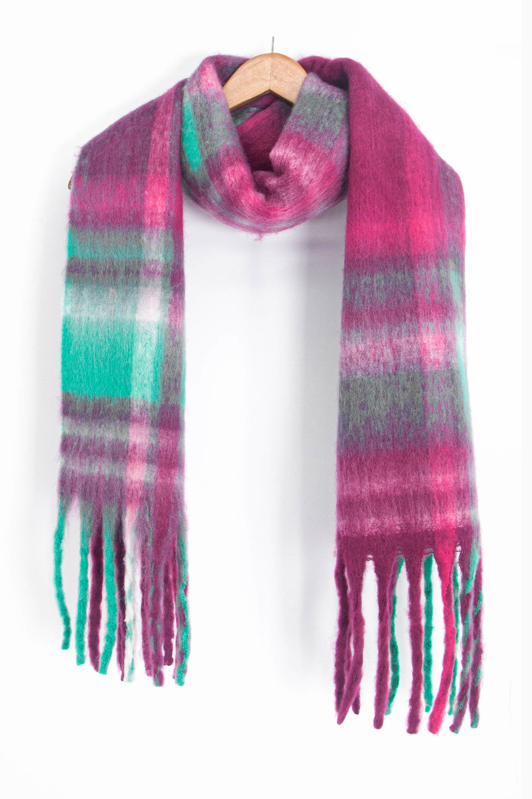 raspberry pink and green tartan scarf draped around a coat hanger, showing how it would look when worn