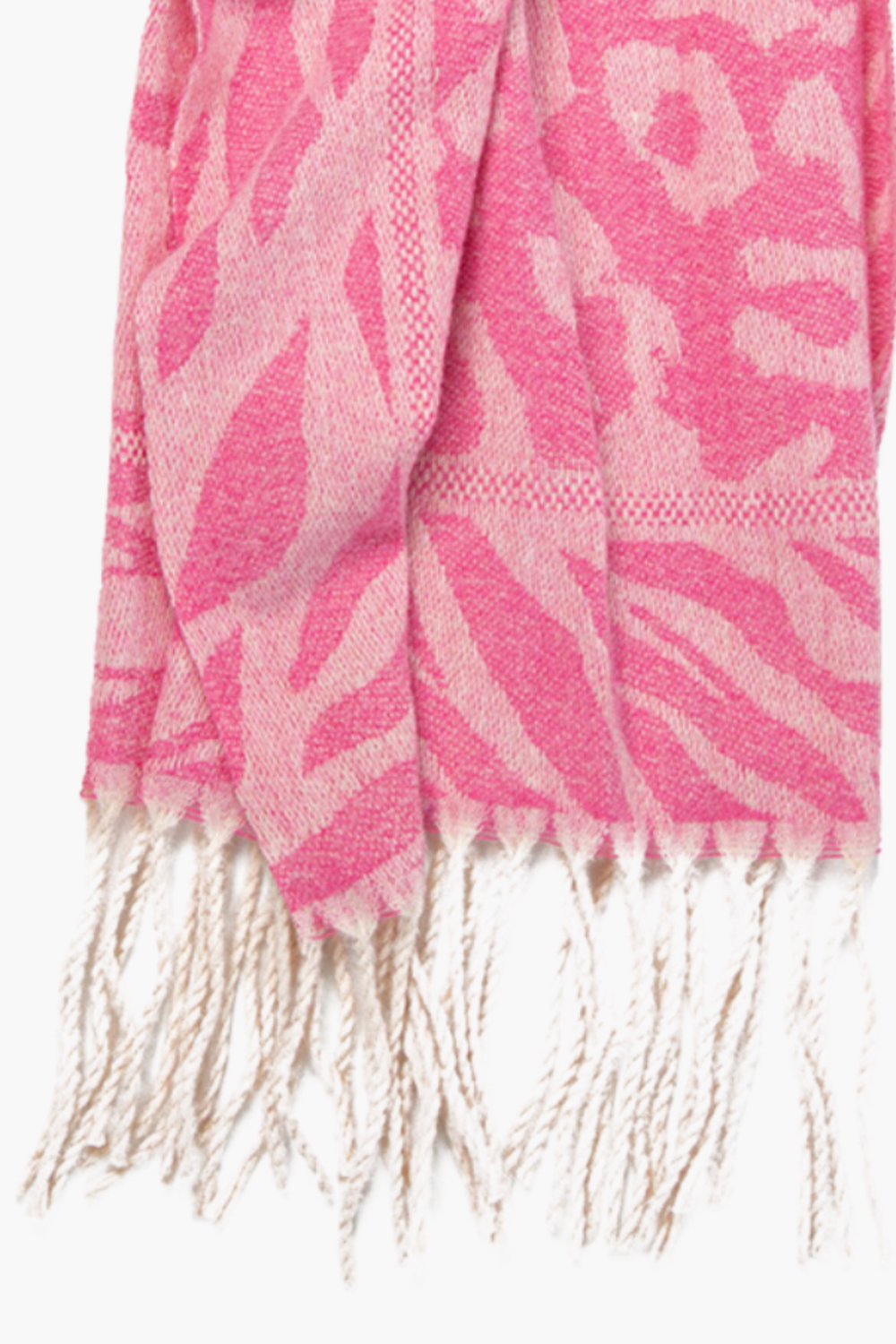 close up of the tasselled fringe and contrasting animal print patterns on the scarf