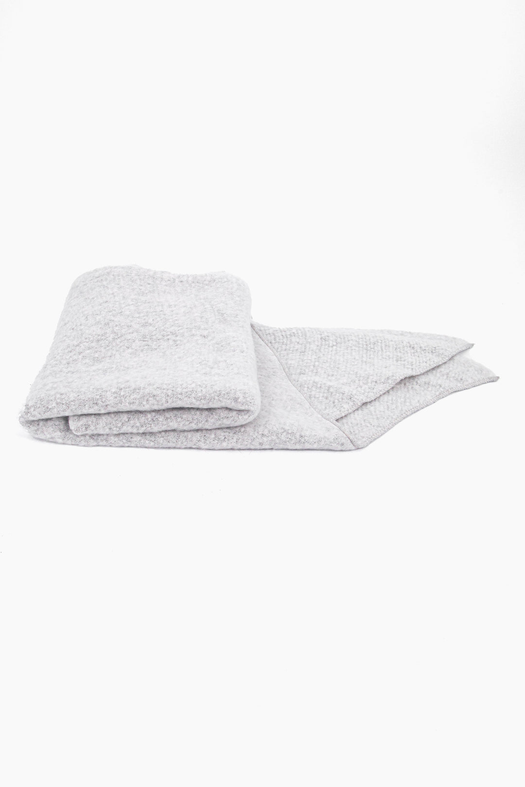 close up of the scarf folded on a flat surface, showing the soft textured fabric