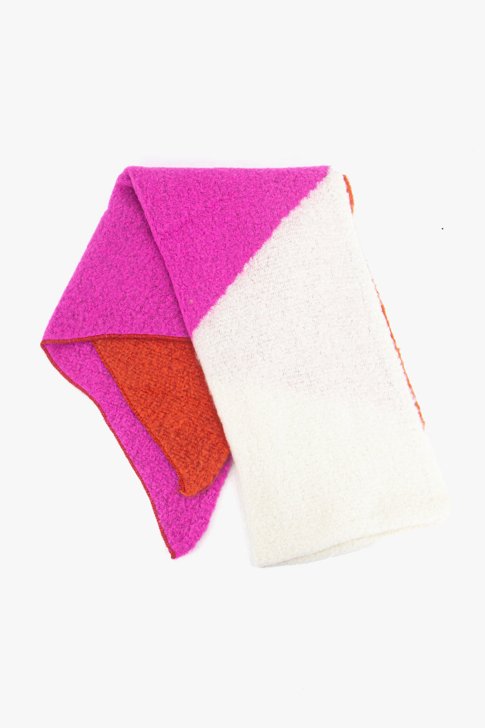 showing the scarf folded while laying flat, the colour block design is shown. there are blocks of pink, coral and white colours in the asymmetric design.