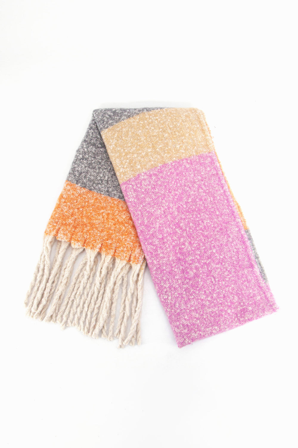 showing the scarf folded while laying flat, the pink, beige, grey and orange colour block design is clearly shown as is the cream tasselled fringe.