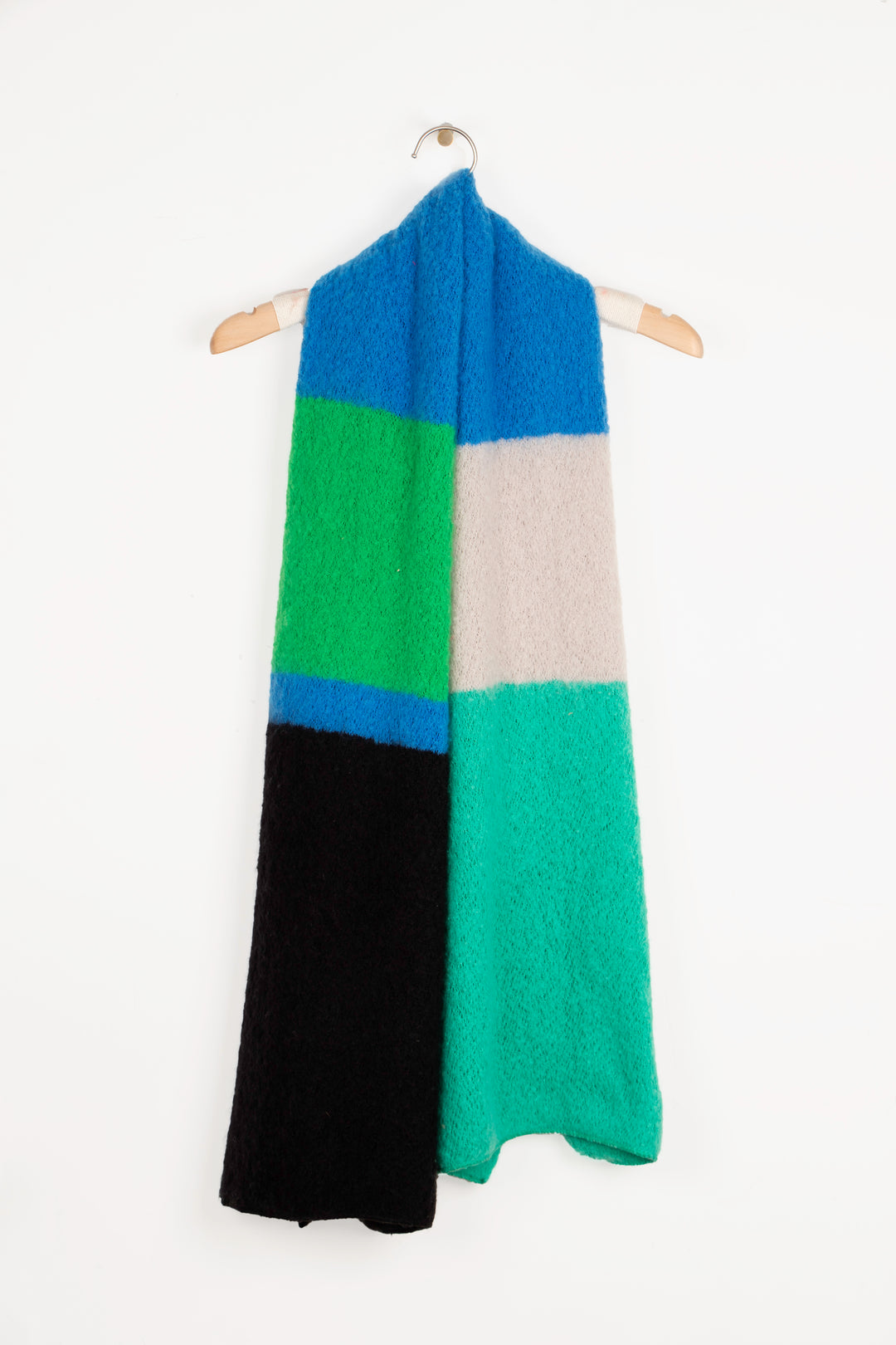 showing the green, blue and black colour block scarf draped around a coat hanger, showing how it can look when worn loosely