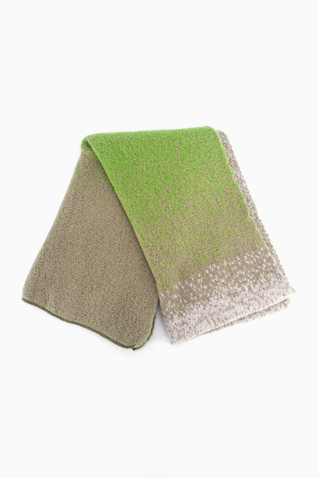 showing the scarf folded while laying flat, the green ombre pattern is highlighted.