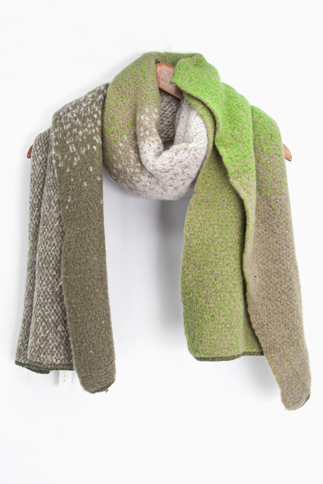 showing the green ombre winter scarf draped around a coat hanger, showing how it would look when worn.