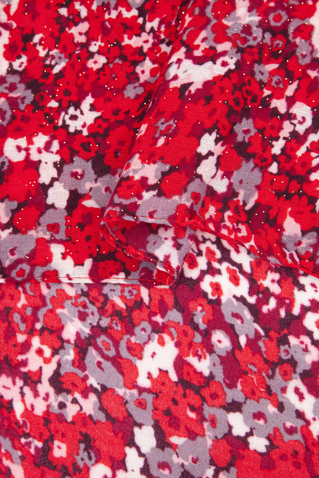 close up of the soft viscose fabric, the red floral print pattern is are clearly visible