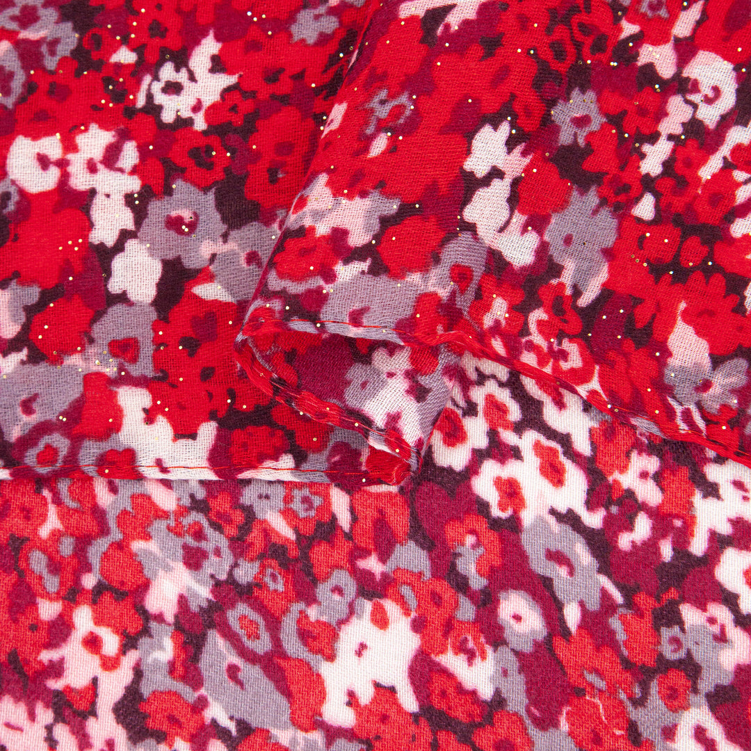 close up of the soft viscose fabric, the red floral print pattern is are clearly visible