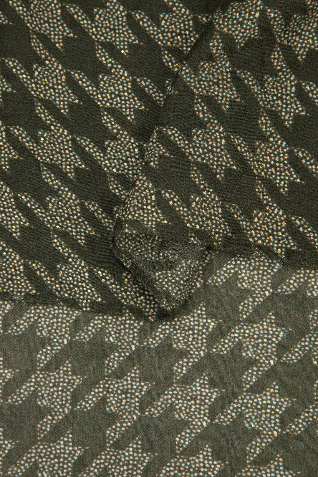 close up of the soft viscose fabric, the khaki green colourway and houndstooth pattern is clearly visible