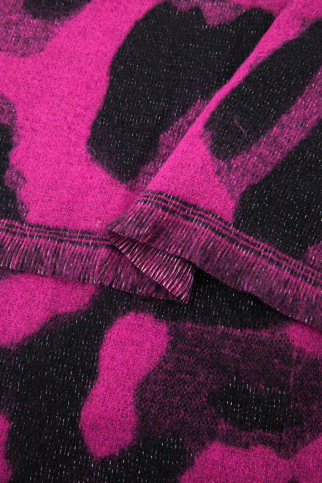 close up of the knitted material of the leopard print winter blanket scarf, the silver glitter sparkle is shown