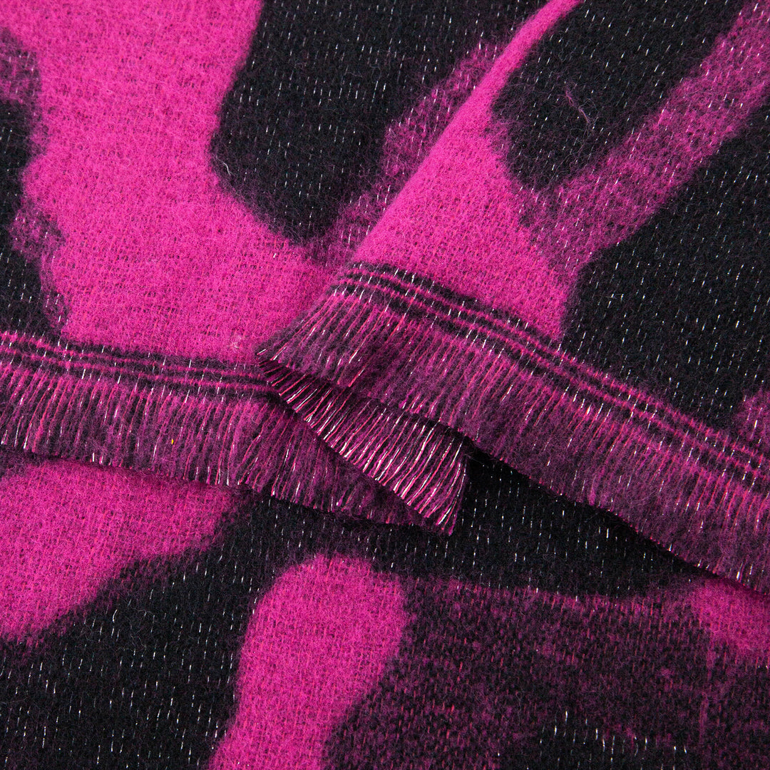 close up of the knitted material of the leopard print winter blanket scarf, the silver glitter sparkle is shown