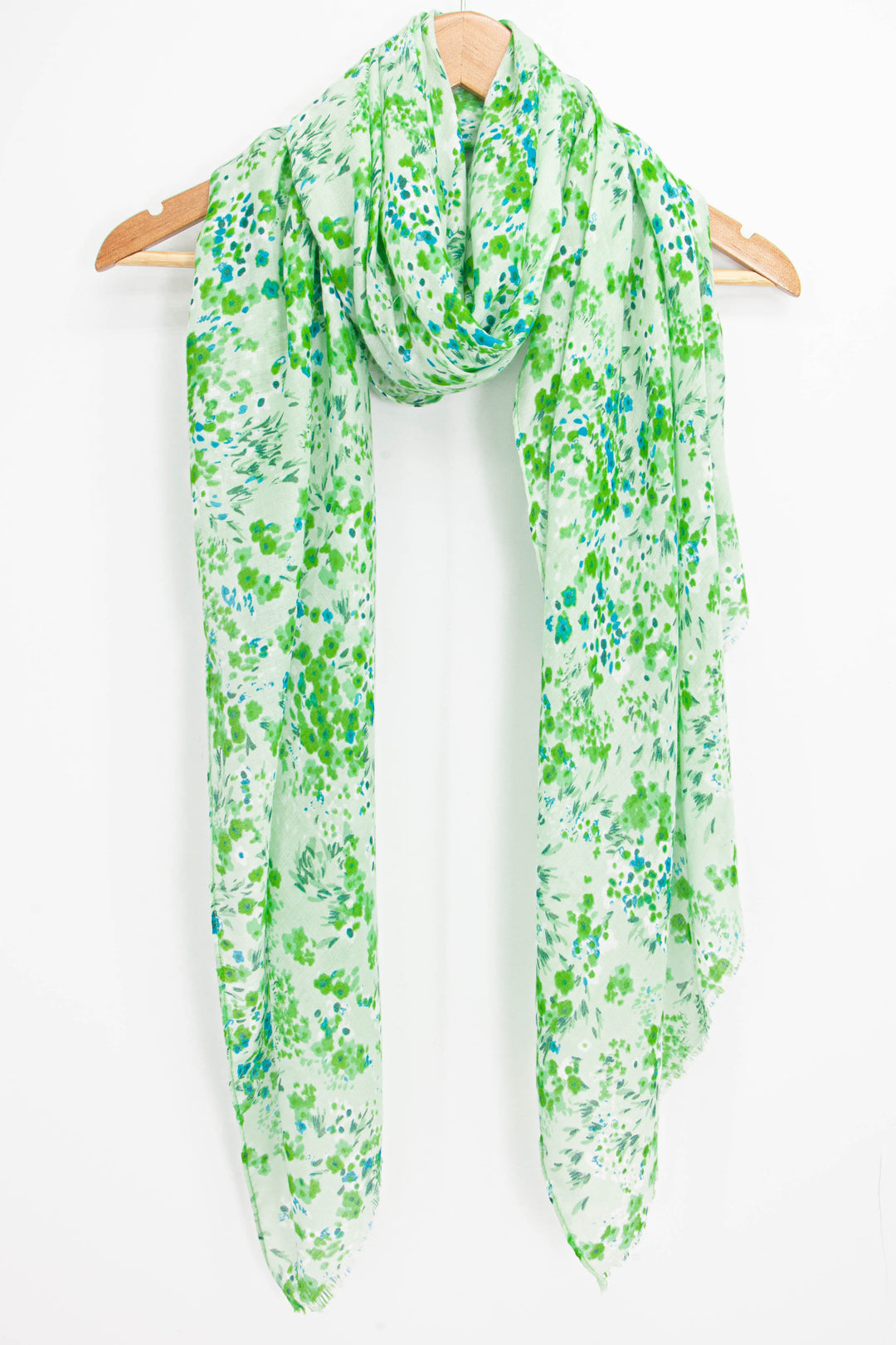 green ditsy floral scarf draped around a coat hanger