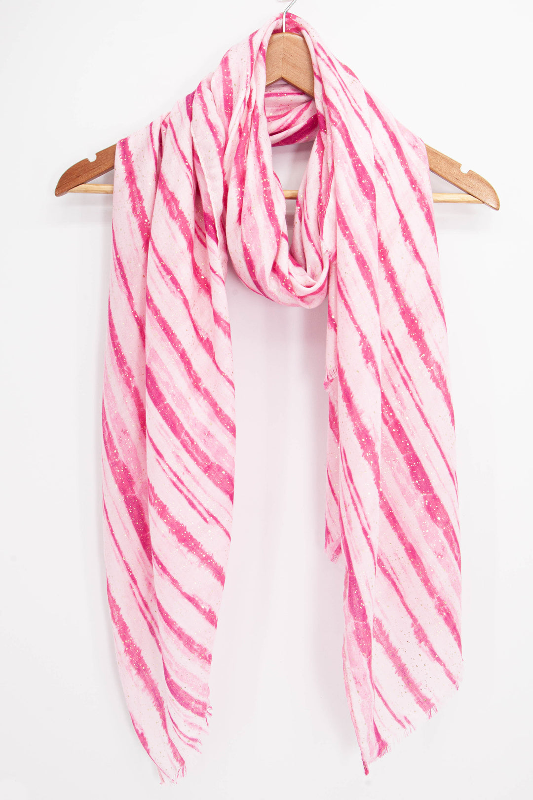 pink striped scarf with gold foil flecks draped around a coat hanger