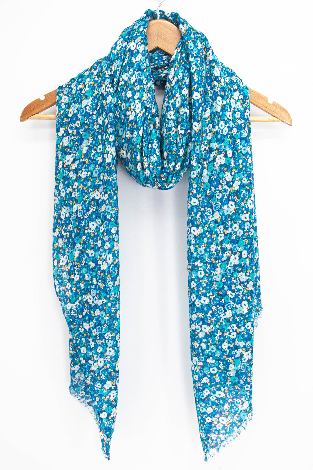blue vintage floral print scarf with gold foil accents draped around a coat hanger