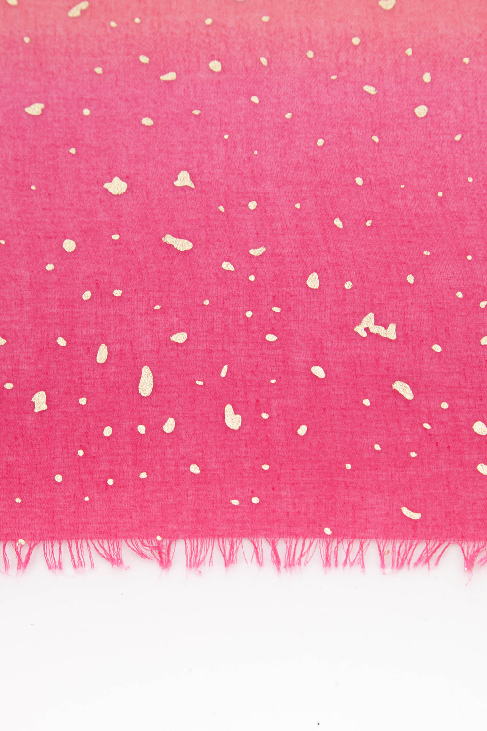 close up of the scattered gold foil pattern on the pink ombre scarf