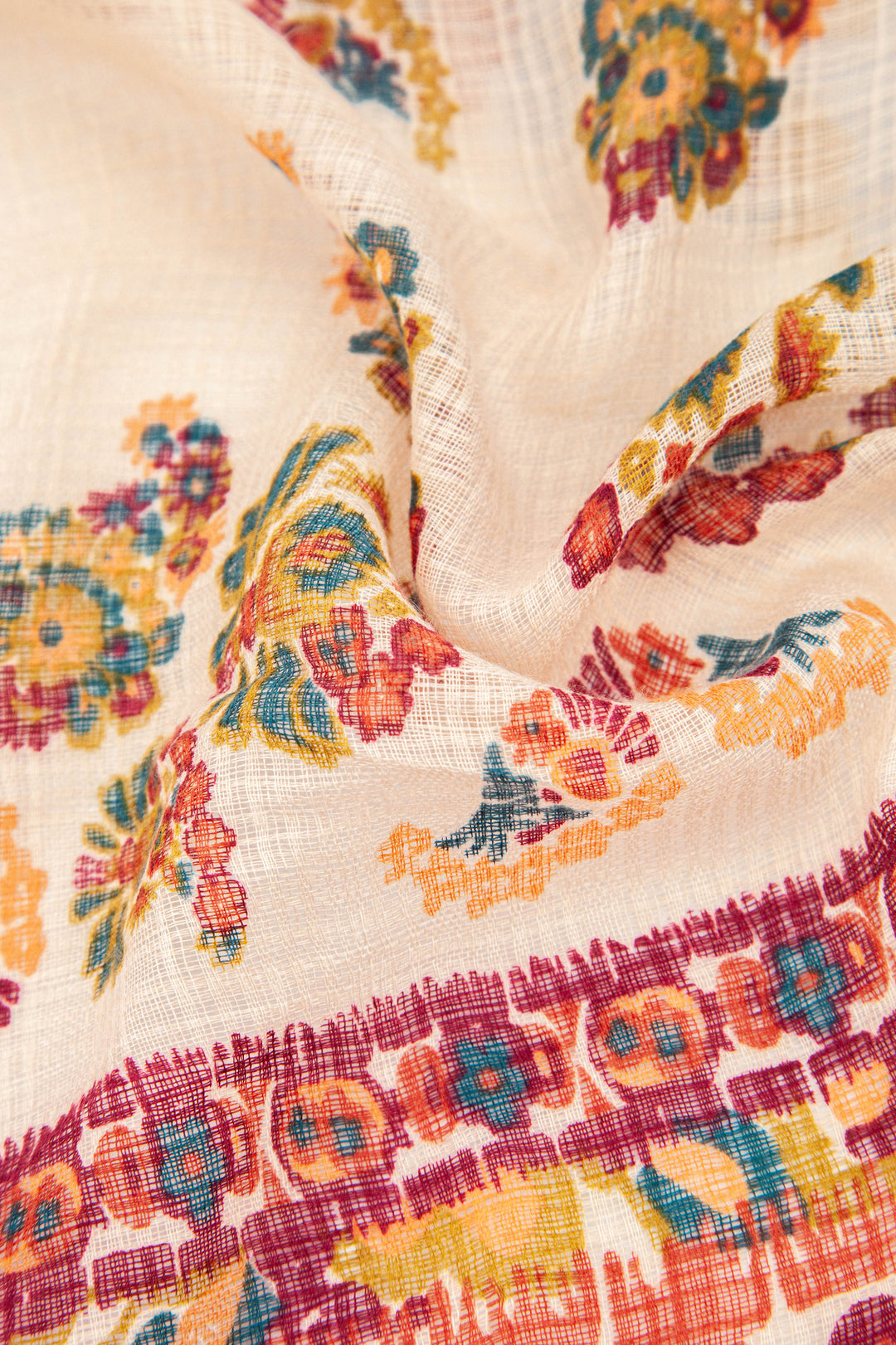 close up of the paisley floral pattern and the lightweight material of this scarf