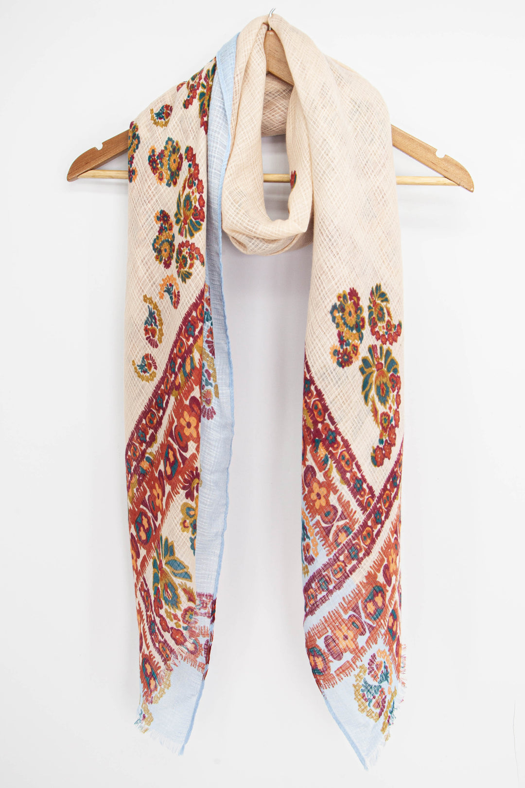 cream and orange paisley floral print scarf draped around a coat hanger showing the vintage style pattern