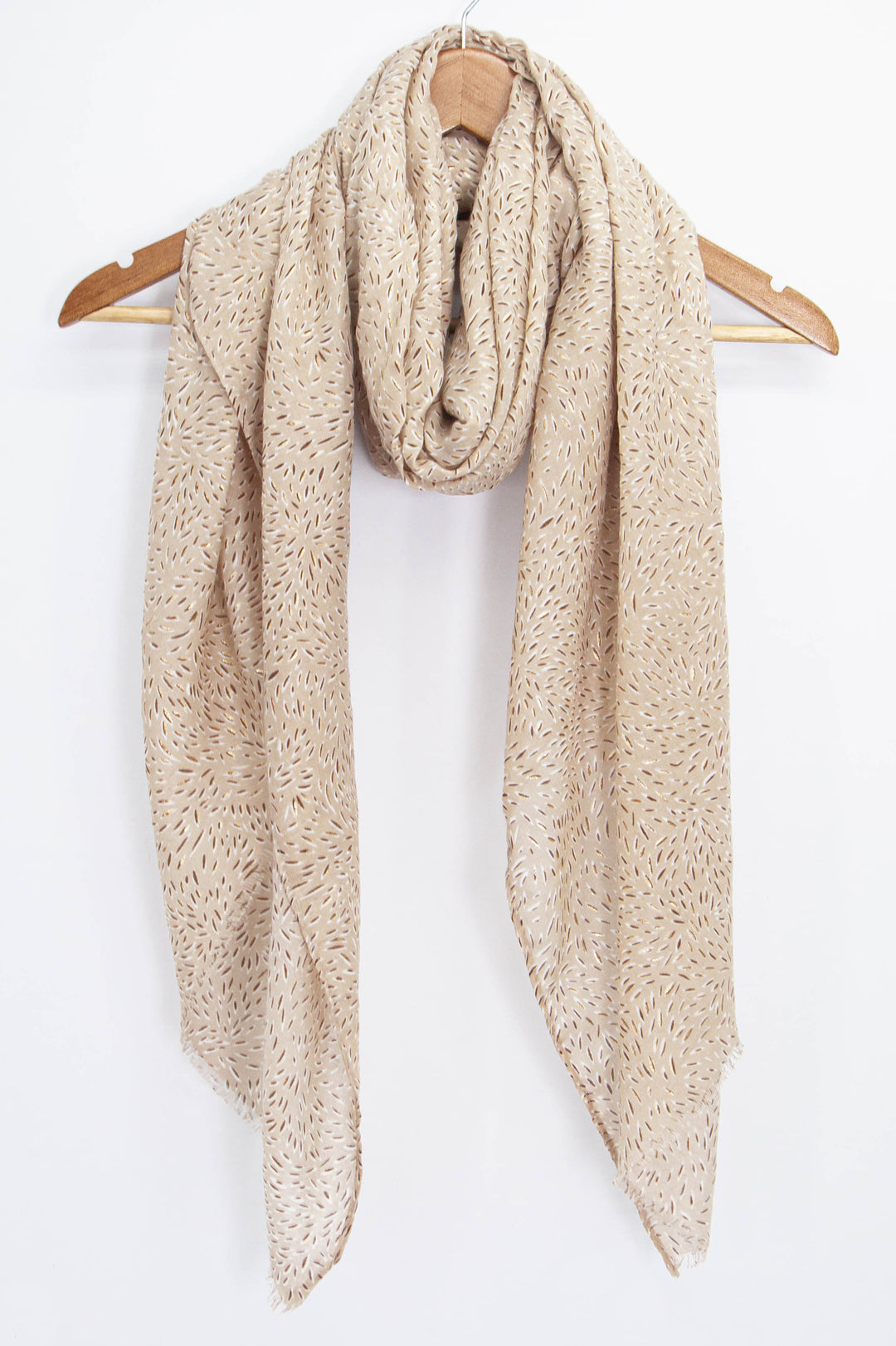 neutral beige summer scarf with an all over floral petal pattern draped around a coat hanger