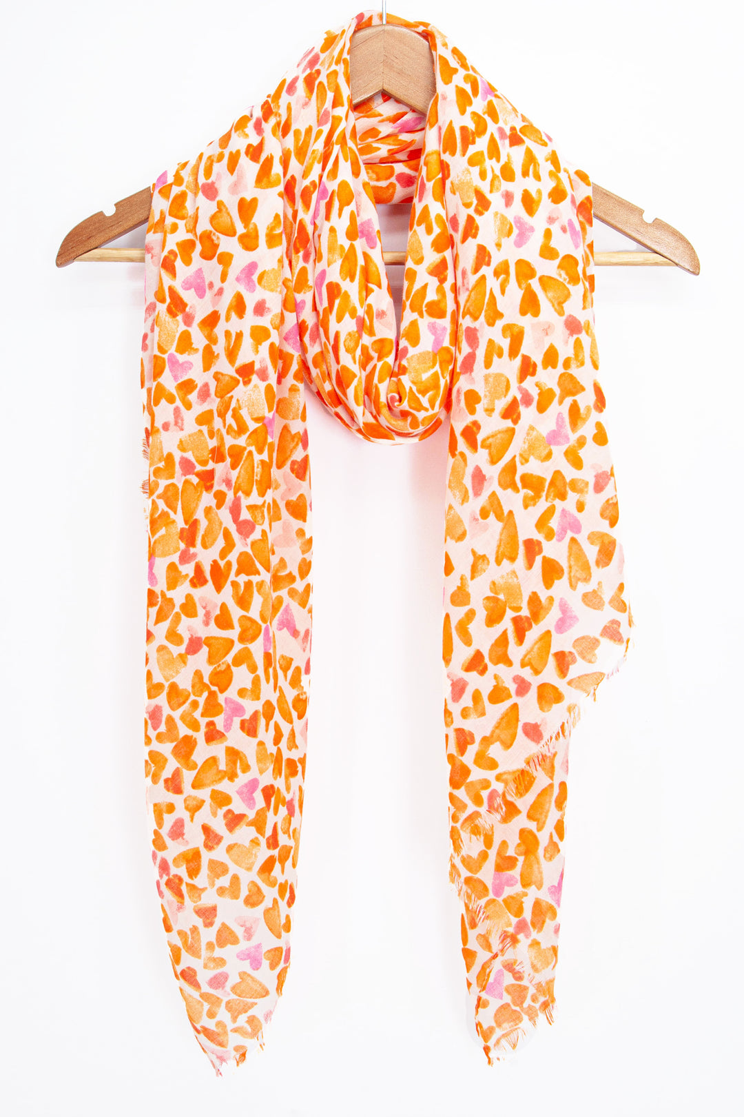 orange heart print scarf draped around a coat hanger