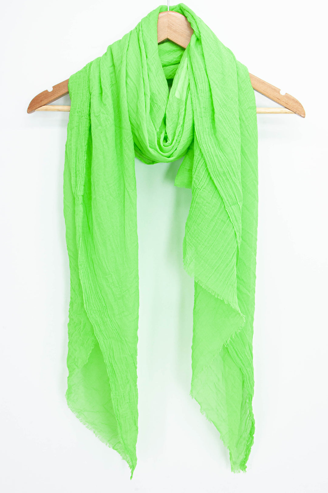 plain neon lime green scarf draped around a coat hanger