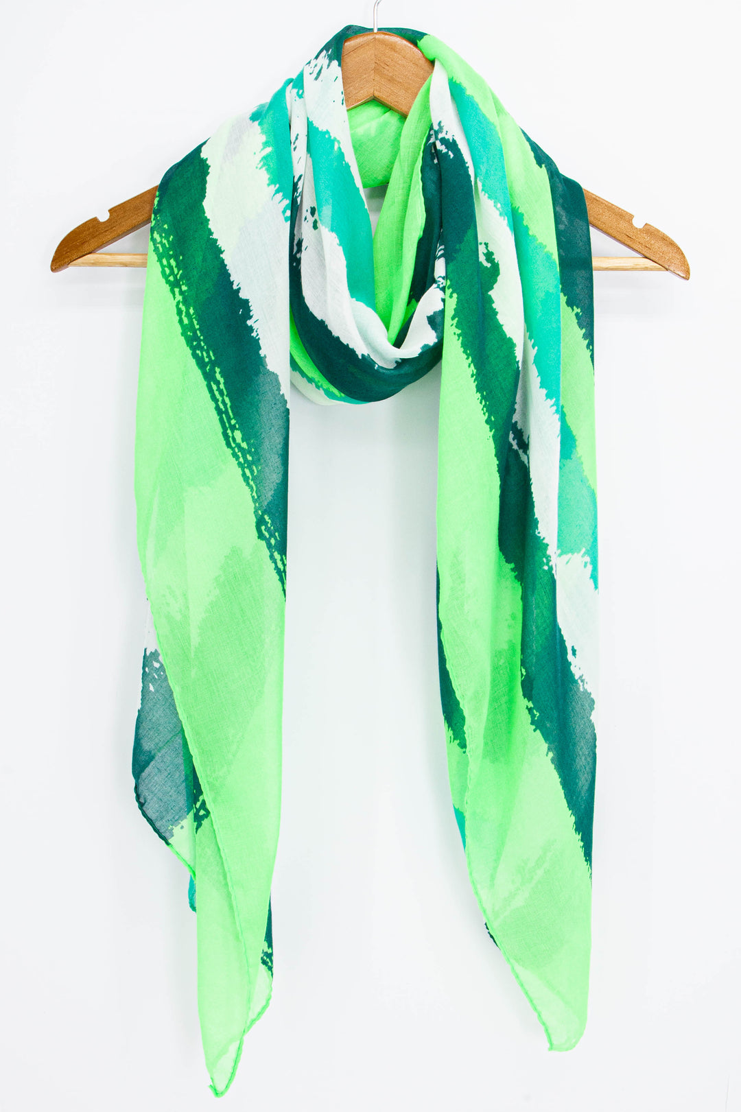 green brushstoke striped scarf draped around a coat hanger