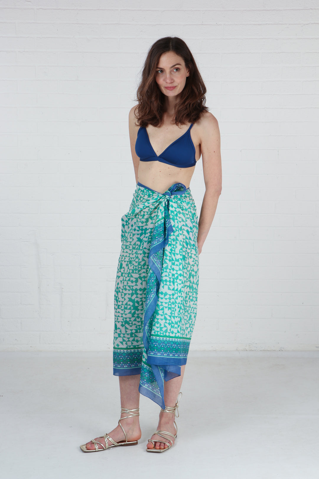 model wearing this green mosaic patterned scarf as a beach sarong skirt