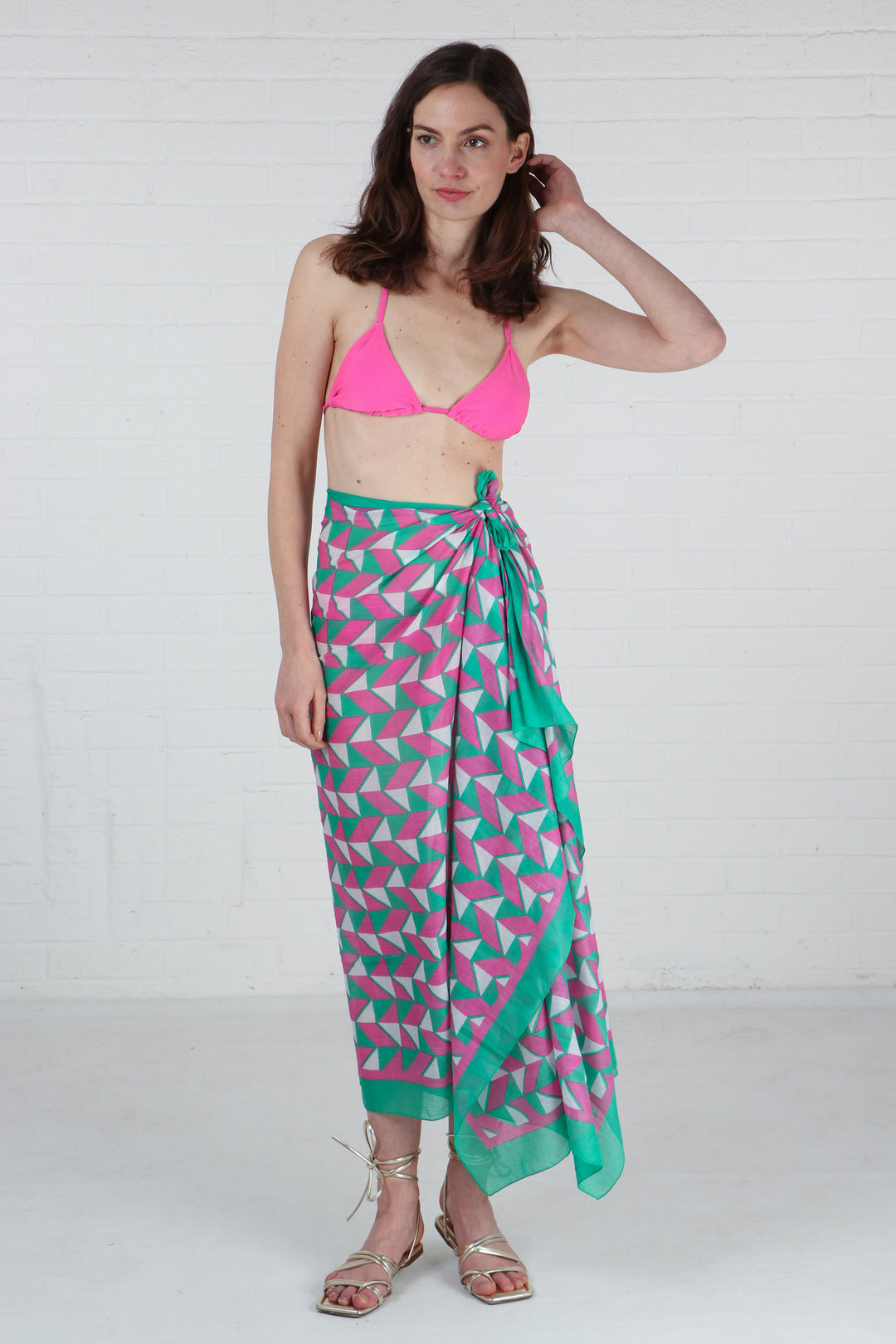 pink and green geometric pattern scarf being worn as a beach cover up