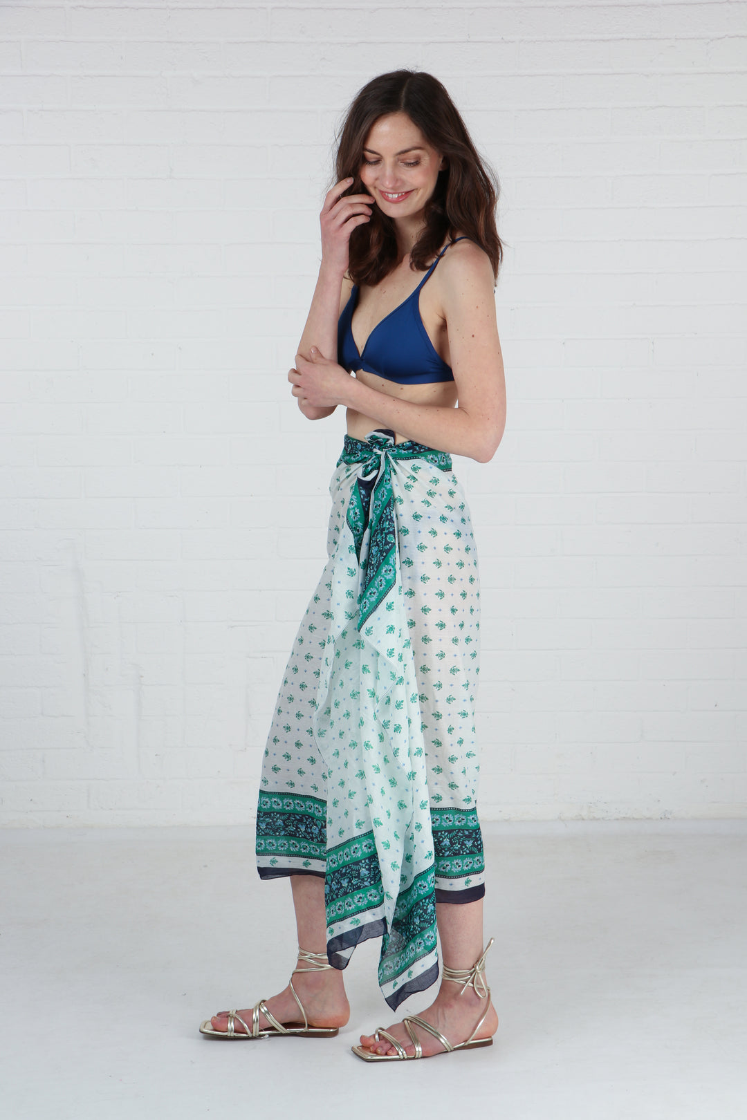green floral scarf being worn as a beach cover up sarong