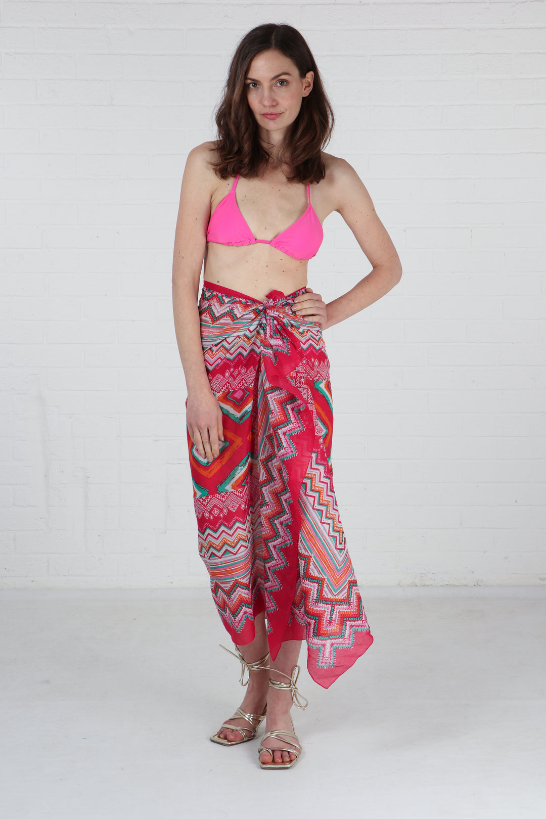 model wearing a pink geometric print scarf as a beach cover up sarong