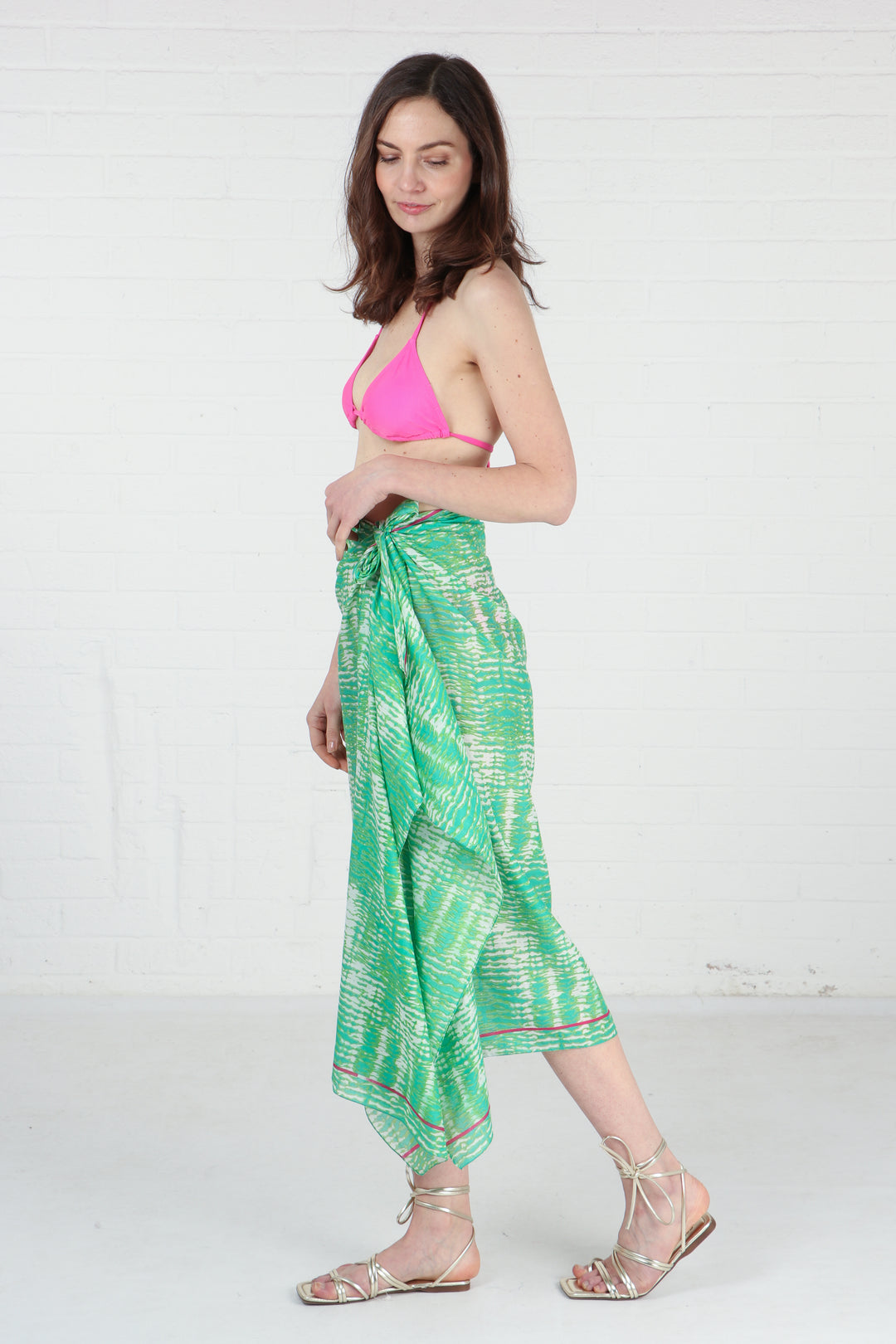 green tie scarf tied around the waist of a model, showing that this can be worn as a beach coverup
