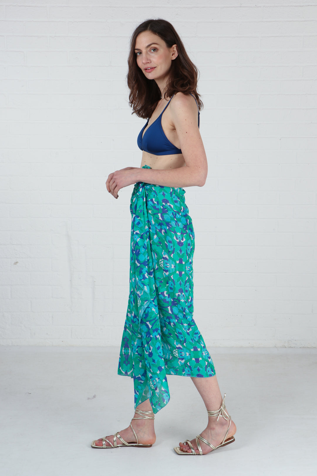 model wearing the abstract print green scarf as a beach sarong skirt