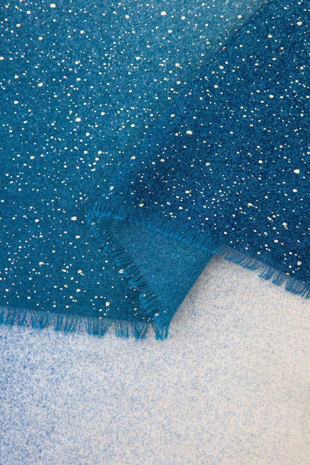 close up of the soft viscose fabric, the blue ombre and foil speckles are clearly visible.