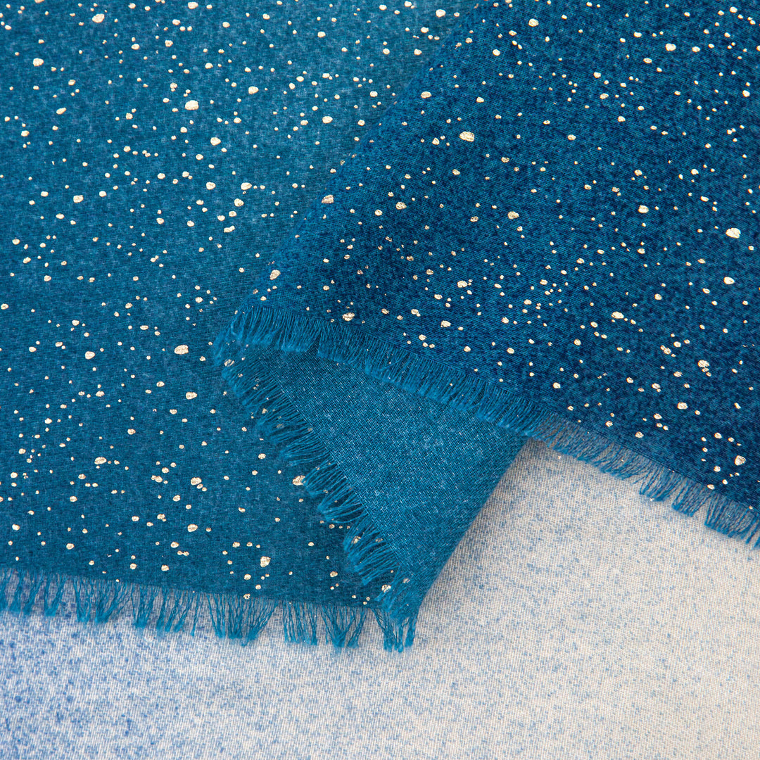 close up of the soft viscose fabric, the blue ombre and foil speckles are clearly visible.