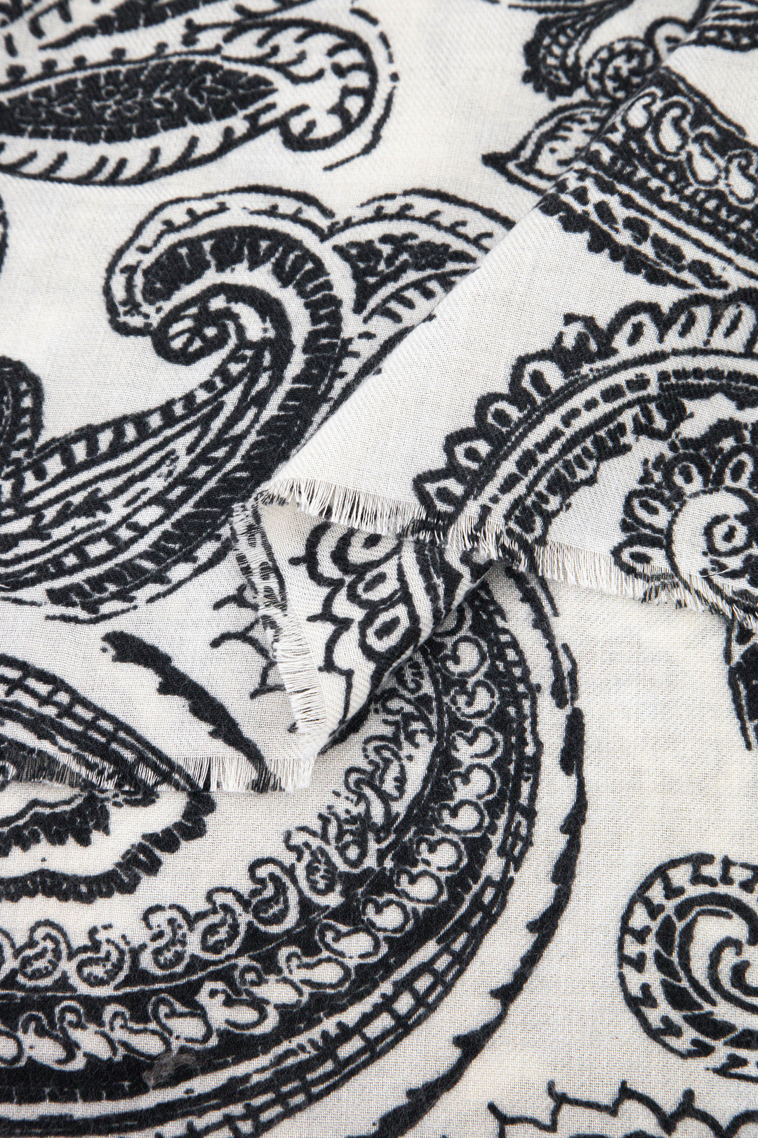 close up of the soft viscose fabric, the cream and black paisley floral design is visible