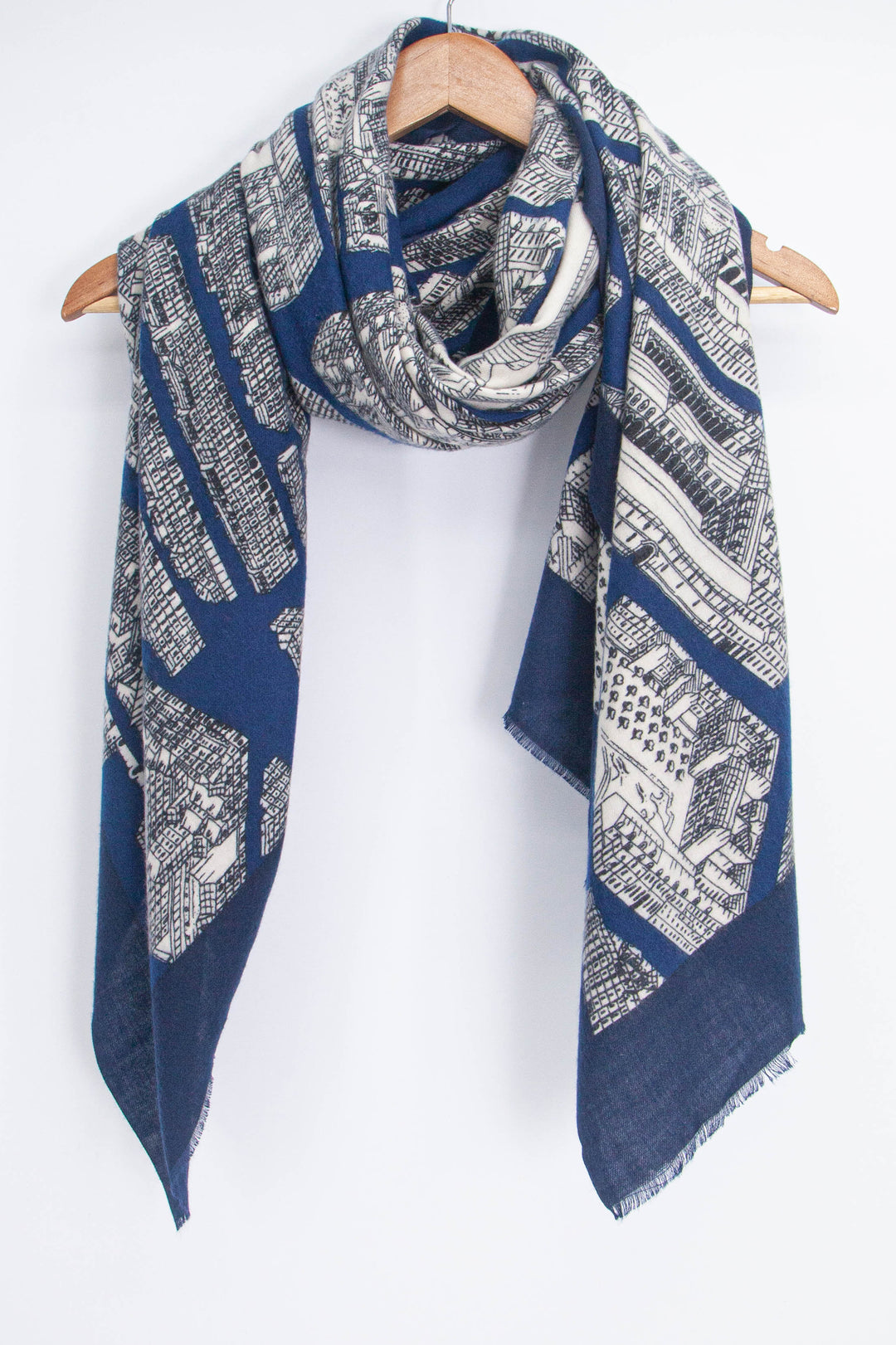 showing the scarf folded, the blue and cream architectural pattern is shown, the scarf also features a plain black border which is also visible in the image.