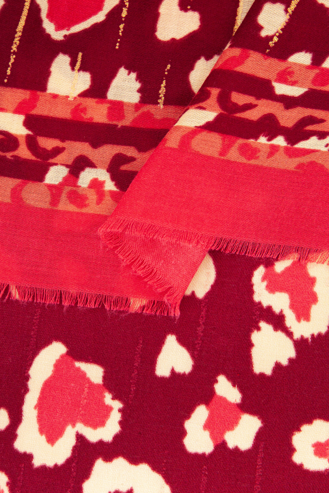 close up of the soft viscose fabric, the red leopard print pattern, plain red border and gold metallic highlights are shown